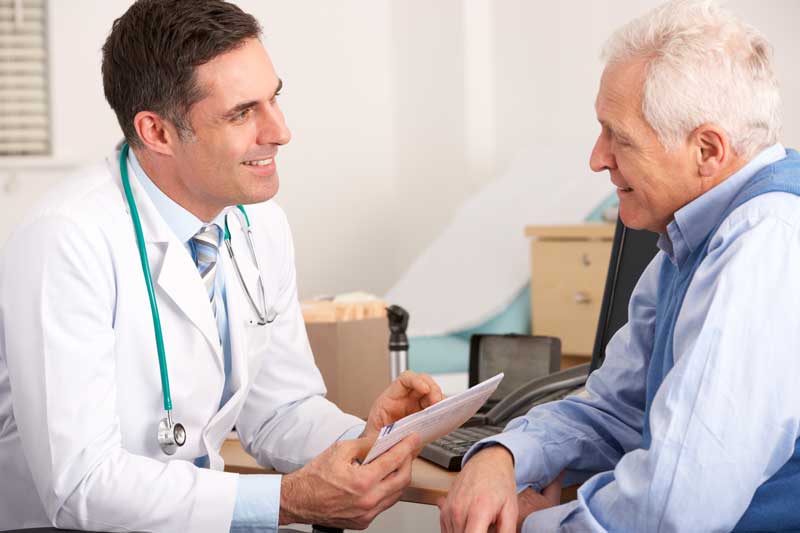 Doctor with Old Patient In Clinic